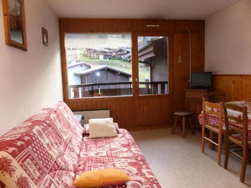 ein Wohnzimmer mit einem Sofa und einem Fenster in der Unterkunft Résidence Le Prarion 2 - Studio pour 4 Personnes 25 in Les Houches