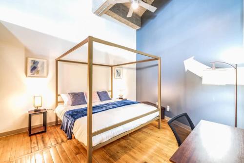 um quarto com uma cama de dossel e uma mesa em TWO Stunning Industrial Lofts by CozySuites em Saint Louis