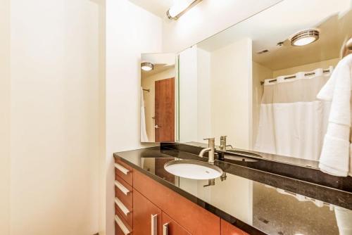 een badkamer met een wastafel en een spiegel bij TWO Stunning Industrial Lofts by CozySuites in Saint Louis