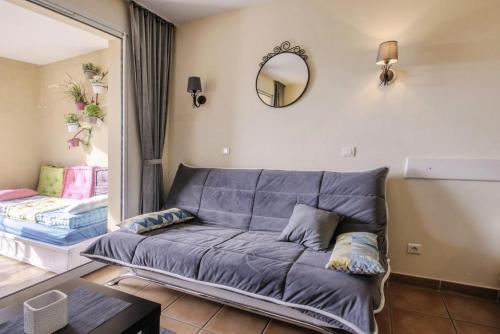 - un salon avec un canapé et un miroir dans l'établissement Village Pont Royal en Provence - maeva Home - Appartement lumineux 2 Pièces 5 P, à Mallemort