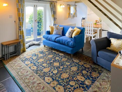 a blue couch and a chair in a living room at High View in Saint Breward