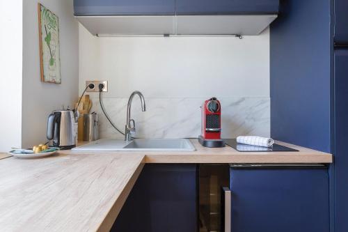 une cuisine avec un évier et un plan de travail dans l'établissement Auguste Comte - Studio tout équipé - Cœur de Lyon, à Lyon
