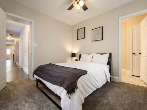 um quarto com uma cama grande e uma ventoinha de tecto em Spacious 3BR House with Backyard in NULU CozySuites em Louisville