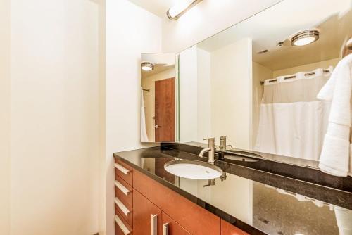 a bathroom with a sink and a mirror at 2BR Architect's STUNNING loft by CozySuites in Saint Louis