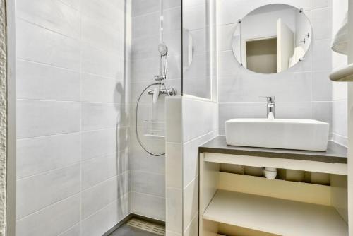 une salle de bain blanche avec un lavabo et une douche dans l'établissement Le Domaine du Golf de Pinsolle - maeva Home - Appartement 2 Pièces 5 Personnes - Confort MAE-3626, à Soustons