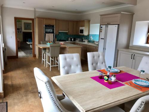 een keuken en eetkamer met een houten tafel en stoelen bij Beautiful 2 Bedroom Barn in Towcester Northants in Litchborough