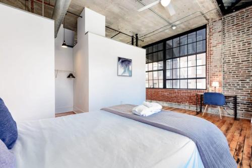 a bedroom with a large bed and a brick wall at Sleeps 3 Stunning 1BR by CozySuites in Saint Louis