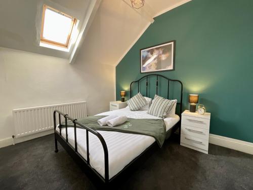 1 dormitorio con 1 cama con pared verde en HNFC Stays - Spacious house w/ all essentials - 3b, en Newcastle