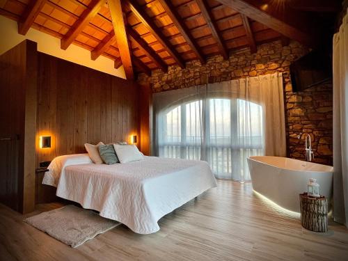 a bedroom with a bed and a bath tub at Alojamiento MAS EL CASTELL DEL BRULL 
