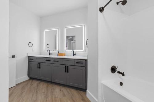 a bathroom with two sinks and a shower at CozySuites Modern Midtown Condo Unit 06 in Nashville