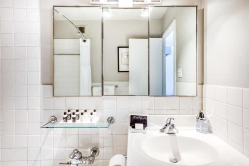 a bathroom with a sink and a mirror at CozySuites 800 Tower 1BR w sky pool, gym! 14 in Louisville