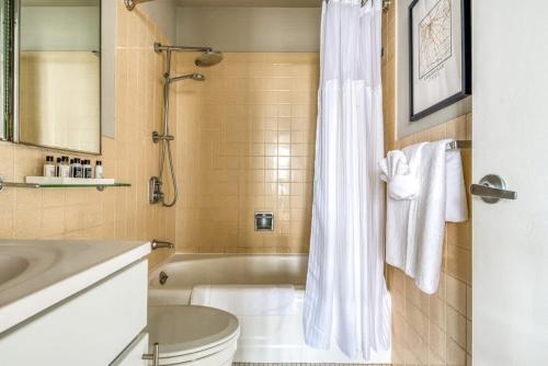 a bathroom with a tub and a toilet and a sink at CozySuites 800 Tower 1BR w sky pool, gym! 12 in Louisville