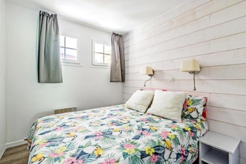 une chambre avec un lit avec un couvre-lit fleuri dans l'établissement Résidence le Village de Cap Esterel - maeva Home - Appartement cosy 2 pièces 5 personnes - Sélection - Super Home MAE-4000, à Saint-Raphaël