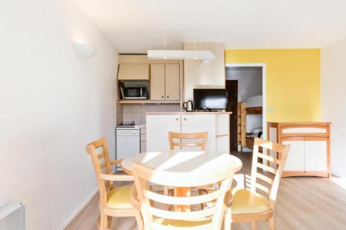 une cuisine et une salle à manger avec une table et des chaises dans l'établissement Résidence Les Tamaris - maeva Home - Studio 4 Personnes Confort MAE-4205, à Trouville-sur-Mer