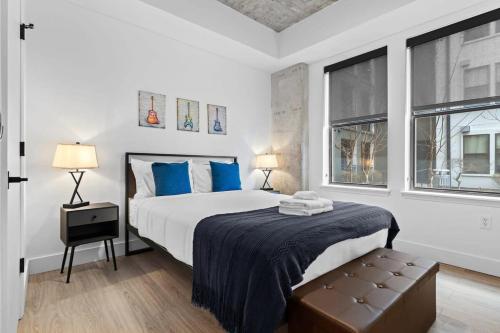 a bedroom with a large bed with blue pillows at CozySuites Modern Midtown Loft 21 in Nashville
