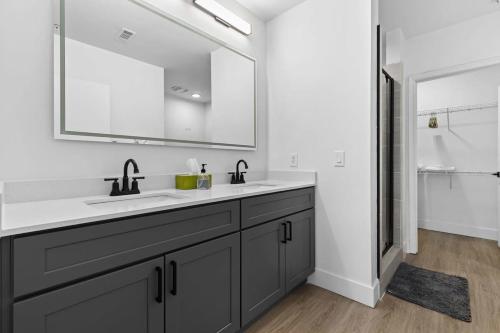 a bathroom with a sink and a mirror at CozySuites Modern Midtown Loft 21 in Nashville