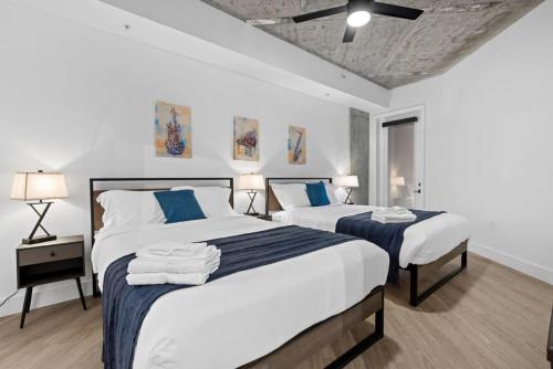 1 dormitorio con 2 camas con sábanas azules y blancas en TWO CozySuites Modern Midtown Loft 25 & 20, en Nashville