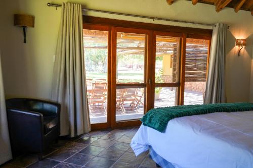 a bedroom with a bed and a sliding glass door at Lucca House in Musina