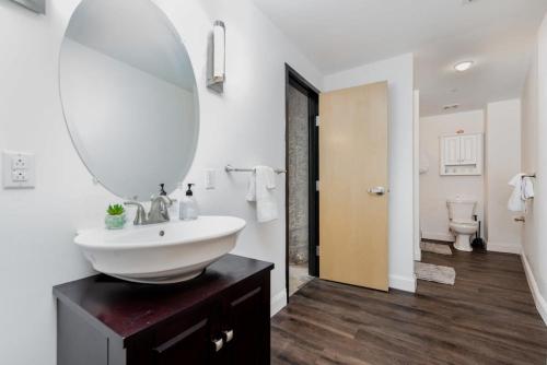 a bathroom with a sink and a mirror at TWO Stunning Adler Loft by CozySuites in Saint Louis