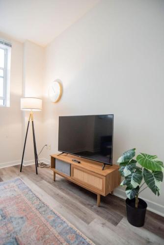 a living room with a flat screen tv on a wooden entertainment center at CozySuites The Block - Direct Skybridge Access #1 in Indianapolis