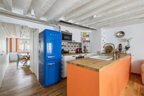 - une cuisine avec un réfrigérateur bleu dans la chambre dans l'établissement Charming marais flat, à Paris