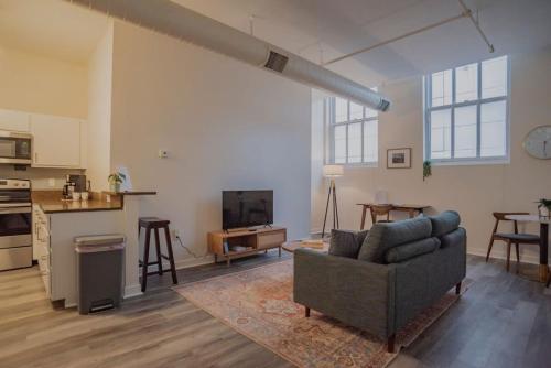 a living room with a couch and a kitchen at CozySuites The Block - Direct Skybridge Access #2 in Indianapolis