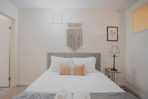 una camera da letto con un grande letto bianco con cuscini bianchi di CozySuites The Block - Direct Skybridge Access #2 a Indianapolis