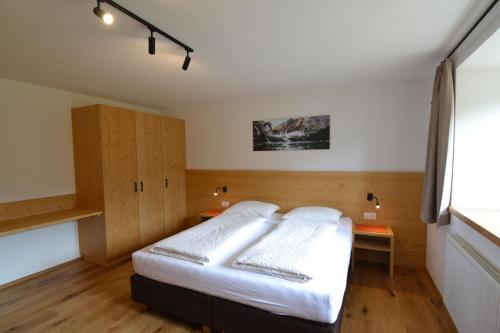 a bedroom with a bed and a desk and a window at SCHETERERHOF in San Candido