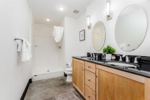 a bathroom with a sink and a toilet and a mirror at TWO Astonishing Adler Loft by CozySuites in Saint Louis