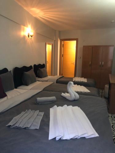 イスタンブールにあるレイデル ホテルのベッド3台(白鳥のタオル付)が備わる客室です。