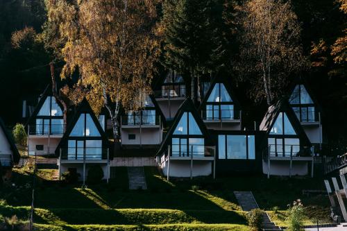 a building with windows and trees in front of it at NOI Resort SPA - woda i las in Tęgoborze