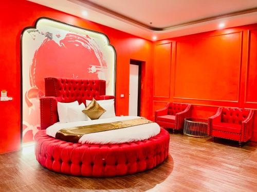 a bedroom with a large bed with red walls and red chairs at Grand Ha Noi Hotel in Hanoi