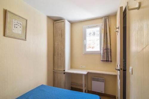 une petite pièce avec un lit et une fenêtre dans l'établissement Les Appartements aux Restanques du Golfe de St Tropez - maeva Home - Appartement avec une belle vue mer 5 personnes MAE-8388, à Grimaud