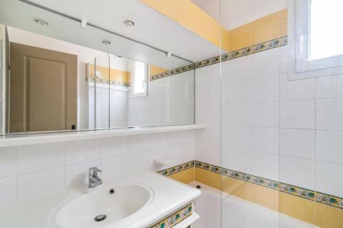 une salle de bain avec un lavabo et un miroir dans l'établissement Les Appartements aux Restanques du Golfe de St Tropez - maeva Home - Appartement avec une belle vue mer 5 personnes MAE-8388, à Grimaud