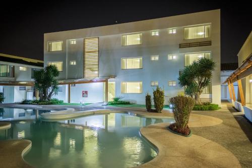 a hotel with a swimming pool in front of a building at Hotel Ajavi in Ibarra