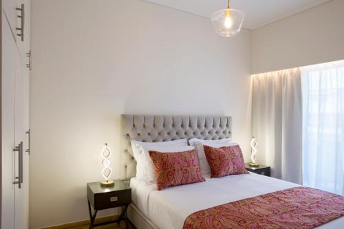 ein Schlafzimmer mit einem großen Bett mit rosa Kissen in der Unterkunft La Residence Athens in Athen