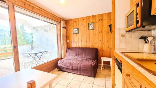 - une cuisine avec une chaise violette dans l'angle d'une pièce dans l'établissement Résidence Arche - Studio confortable · Centre station · Terrasse MAE-7414, à Flaine