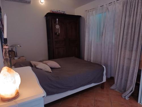 ein Schlafzimmer mit einem Bett und einem Tisch mit einer Lampe in der Unterkunft Maison au calme dans le var in Roquebrune-sur-Argens