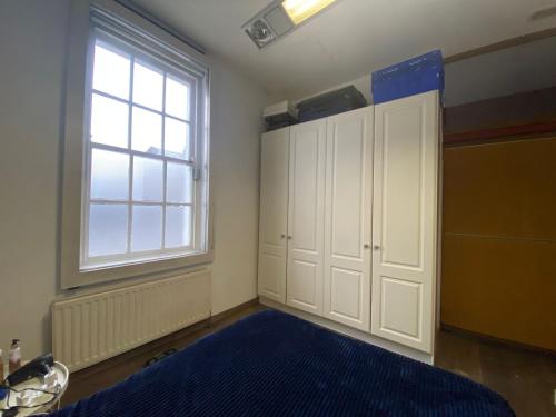 a bedroom with a bed and a large window at Excellent Located House for Saint Patrick's in Dublin
