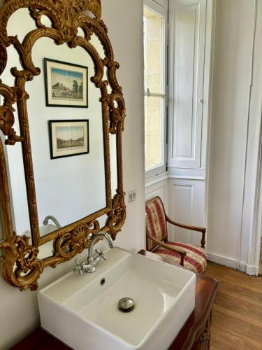 une salle de bain avec un lavabo blanc et un miroir dans l'établissement Château de la Pervenchère gîte Baroque, à Casson