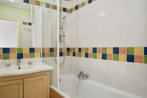 La salle de bains est pourvue d'une baignoire, d'un lavabo et d'une douche. dans l'établissement Village Pont Royal en Provence - maeva Home - Appartement 4 pièces 7 personnes, à Mallemort