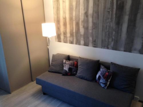 un canapé dans une pièce avec un tableau mural dans l'établissement Studio 2 personnes plages et criques - Studio 2 personnes MAE-9614, à Bormes-les-Mimosas