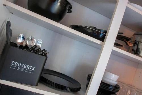 a shelf with utensils in a kitchen at BEL APPART rénové en face des universités in Brunstatt