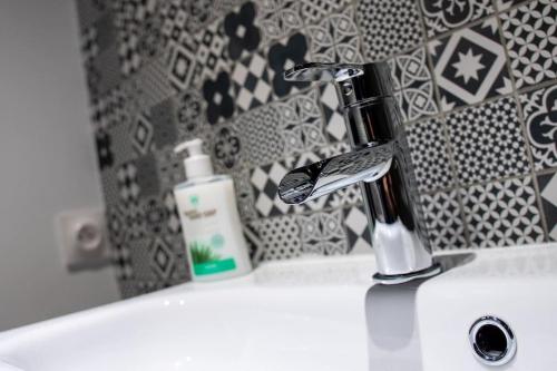 un lavandino in bagno con spazzolino da denti e una bottiglia di sapone di BEL APPART rénové en face des universités a Brunstatt