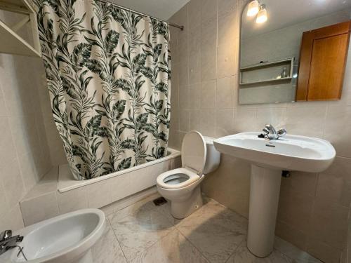 een badkamer met een wastafel, een toilet en een spiegel bij Apolo XI Calpe vistas al mar in Calpe