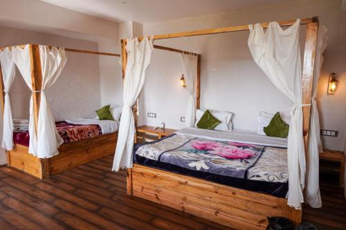a bedroom with two beds with flowers on it at Greetoe Camp Panna in Khajurāho