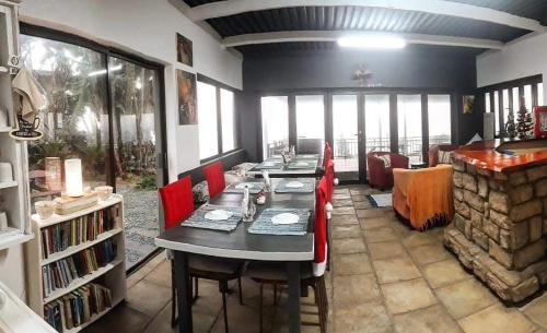 a dining room with a table and red chairs at Bayview Guest House in Amanzimtoti
