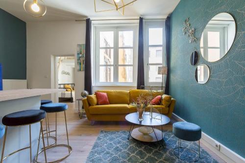 uma sala de estar com um sofá amarelo e uma mesa em Hamac Suites - Le Mercière - Centre Lyon II -6pers em Lyon