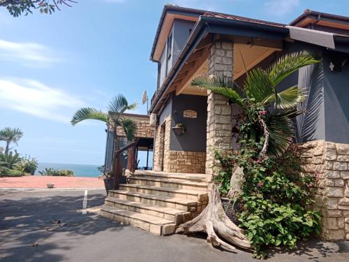 ein Haus mit einer Palme davor in der Unterkunft Bayview Guest House in Amanzimtoti