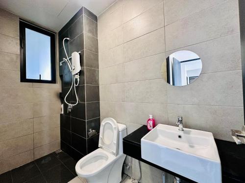 a bathroom with a sink and a toilet and a mirror at Cozy & Drive Urban Suite by WL in Jelutong
